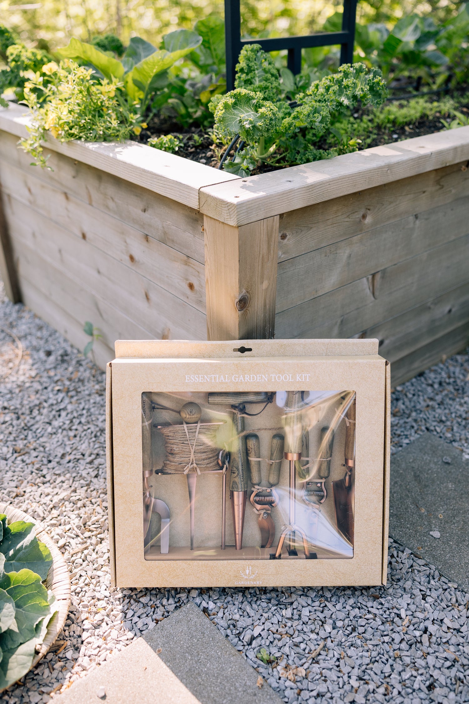 Copper tool set on a gravel surface with a garden in the background