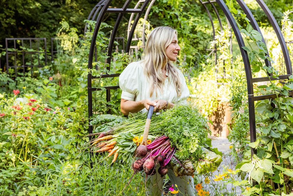 Woman holding a basket of vegetables in a garden