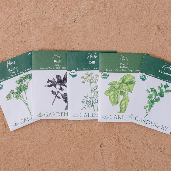 Set of five Gardenary herb seed packets with herb illustrations on a brown background